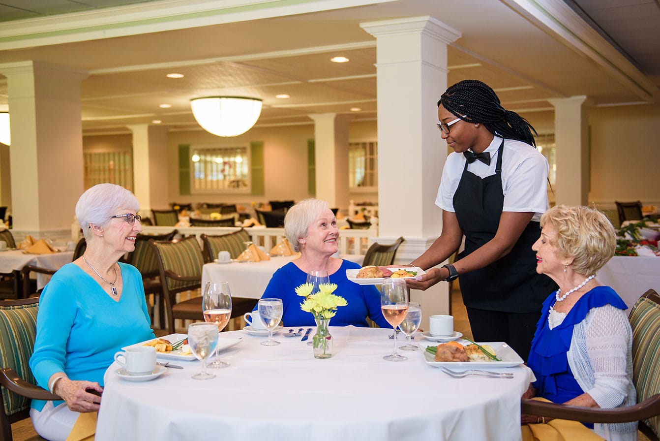 Senior woman at lunch with waitress and food