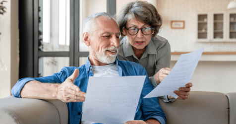 Elder man and woman in the living area on sofa comparing the costs of senior living