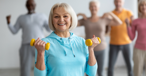 Senior woman in an aerobics class lifting weights.