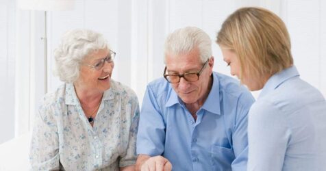 A group of elderly people learning to budget for senior living while looking at a computer.