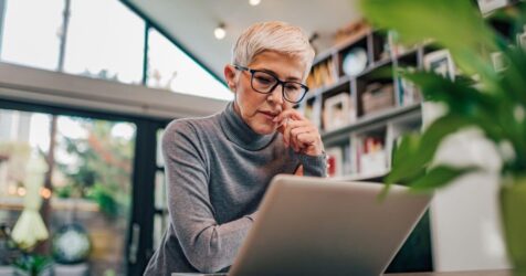 Woman at a computer desk reviewing when it's right for senior living for solo agers.