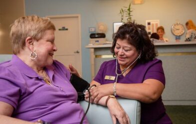 A nurse checks a patient's blood pressure.